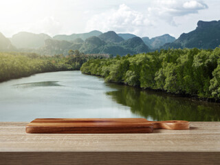 Wooden cutting board on table for standing product against nature landscape
