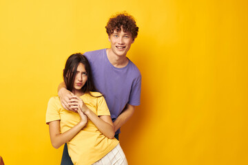 Naklejka premium portrait of a man and a woman casual clothes posing emotions antics yellow background unaltered