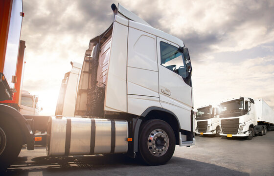 Semi Trailer Trucks on the Parking lot at The Sunset Sky. Delivery Trucks. Cargo Shipping. Lorry. Industry Freight Truck Logistics Cargo Transport Concept.	