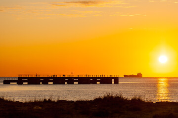 Oil tanker and pier at sunrise