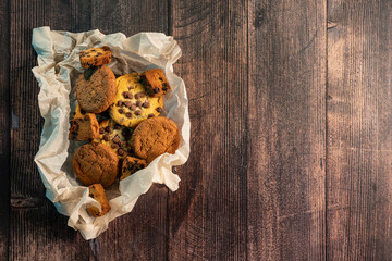 Homemade cookies with chocolate, nuts and coffee beans on a  wooden background  with a background blur.