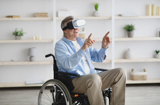 Happy senior man in wheelchair using VR headset to explore augmented reality at home