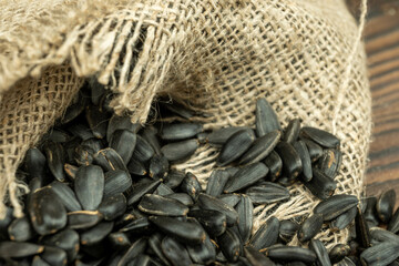 Sunflower seeds are scattered on homespun fabric with a rough texture. close-up, selective focus.