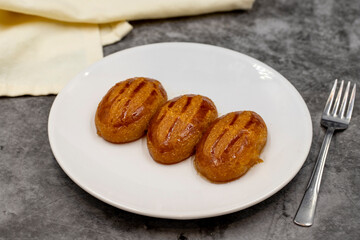Traditional Turkish dessert sekerpare on a dark background. Turkish dessert with syrup, ramadan and feast treat. Close up