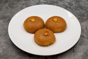 Traditional Turkish dessert sekerpare on a dark background. Turkish dessert with syrup, ramadan and feast treat. Close up