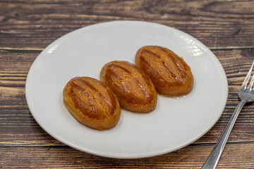 Traditional Turkish dessert sekerpare on a wooden background. Turkish dessert with syrup, ramadan and feast treat. Close up
