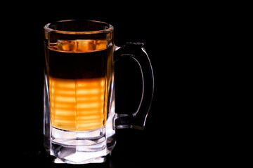 glass mug with beer without foam on a black background. low-alcohol drink. brewery. soft drink.