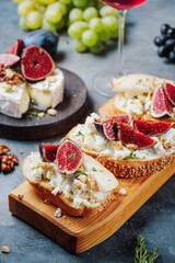 red wine bruschetta set with pears, cottage cheese, figs, thyme, nuts and honey, grapes. wine snacks, camembert cheese