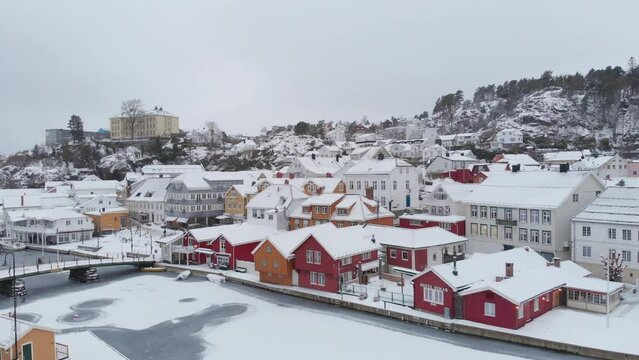 Winter Landscape With Houses Covered In Snow In Kragero City, Norway - aerial drone shot
