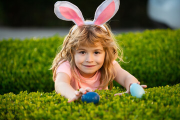 Kids boy hunting easter eggs. Easter bunny kids. Child boy in bunny Easter ears hunt eggs. Kids in...