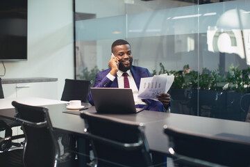 Happy black businessman having phone conversation with assistant