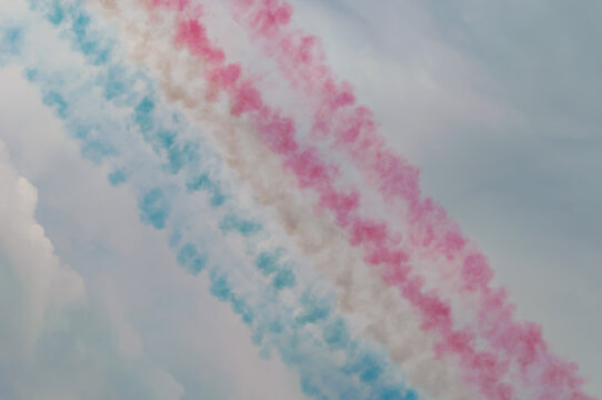 Blue white and red colored airplane contrails from airshow aviation performance