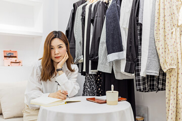 Startup small business, Young chinese woman Entrepreneur using weekly planner in store