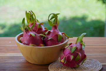 Dragon fruit on wooden table with  green bokeh background.