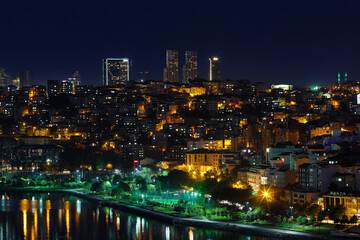 Fototapeta na wymiar View of the sea bay Golden Horn, the city at the night, skyscrapers. The lights on in the houses. Journey to istanbul