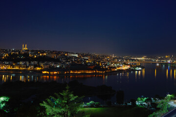 Fototapeta na wymiar View of the sea bay Golden Horn, the city at night, in the houses with the lights on. Journey to istanbul