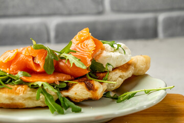 Croffles with salted salmon, arugula and cheese, Sandwich. Close-up.