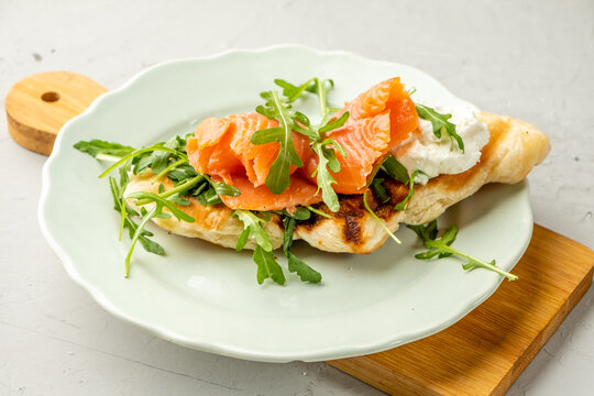 Salted salmon sandwich with arugula, soft cheese on croffle.