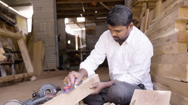 Carpenter busy working using block plane for removing rough surfaces - concept of artisans, self employed and blue collar jobs