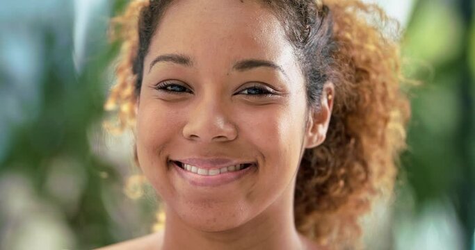 Coaxing out a smile. Portrait of a beautiful young African American woman smiling.Face of a a confident young woman with a bright smile looking at the camera