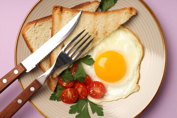 Plate of tasty breakfast on violet background