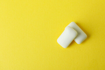Chewing or bubble gum on yellow background, close up