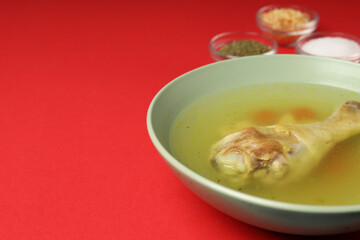Concept of tasty food with chicken soup on red background