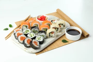 Selbstklebende Fototapeten Concept of tasty food with sushi rolls on white background © Atlas