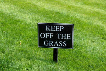 Keep Off the Grass sign on a nicely kept lawn in a park