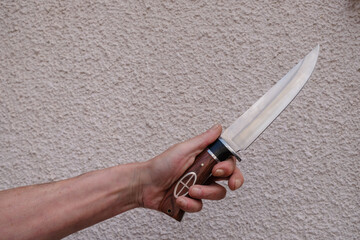 Male hand with a dagger. Threatening knife gesture.