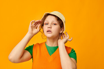 cute girl wearing hat posing orange sweater isolated background