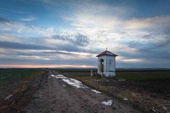 an old chapel by a dirt road
