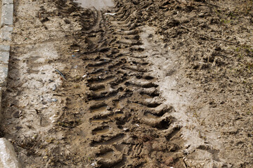 Track from the wheels of a tractor on a dirt road, the problem of the quality of the road surface and road construction