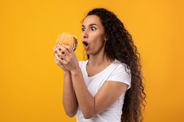 Funny Latin Lady Holding Burger At Studio - obrazy, fototapety, plakaty