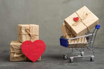 Valentine's Day greetings concept. Gift boxes in a shopping cart and red heart shaped card with empty space for your text. Valentines greeting card. - 484849894