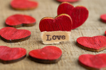 Valentine's Day greetings concept. Little red wooden heart and text Love close up. Valentines...