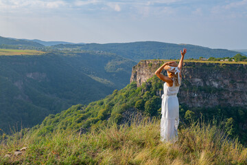 girl waving on the slope of the canyon in georgia