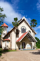 Fototapeta na wymiar St Anne’s Catholic Church in Baie Ste Anne, Praslin Island, Seychelles, white church building with palm trees and tropical vegetation around.