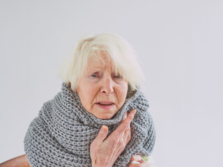 senior ill woman in scarf freezing cold at home. Health care, crisis, oldness concept