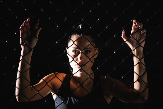 The Idea Of Overcoming Psychological And Physical Barriers And Obstacles Young Athletic Woman Looks At You Through The Mesh