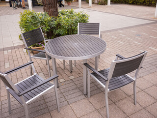 Fototapeta na wymiar empty modern steel round table and 4 chairs and green plants in the cafeteria outside the mall 