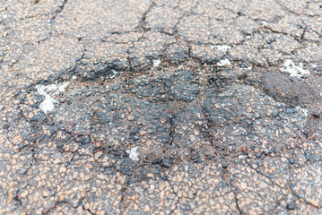 Damaged road. Deep crack on the asphalt. Closeup.view from above.