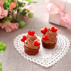 Fototapeta na wymiar Chocolate cupcakes with chocolate cream with strawberry heart. Valentine bouquet of rose flowers and gift.　チョコレートカップケーキ　バレンタイン　バレンタインデー