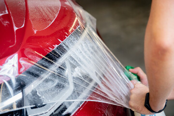 Concept transparent protection for car paint. Instal protective vinyl film from gravel chips and...
