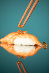 Putting caviar with chopsticks on sashimi sushi