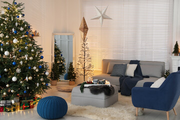 Cozy living room interior with beautiful Christmas tree and comfortable furniture