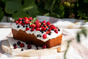 authentic homemade cakes, cupcake with berries and cream on wooden tray, sweet picnic