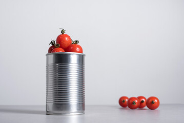 Tomates cherry enteros dentro de una lata de conservas sobre fondo gris	 - obrazy, fototapety, plakaty