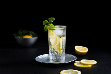 Un vaso de refrescante zumo de limón, cóctel de frutas con rodajas de limón y hielo sobre fondo...