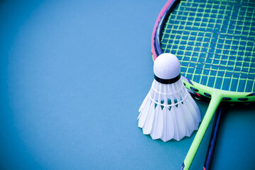 Cream white badminton shuttlecock and racket on floor in indoor badminton court, copy space, soft and selective focus on shuttlecocks. - obrazy, fototapety, plakaty